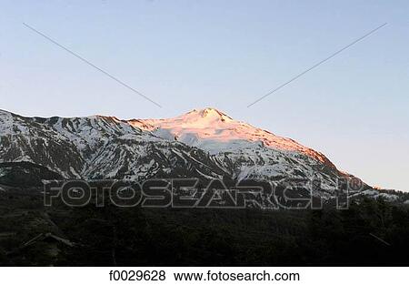 Stock Photo - France, Alps, Ubaye Valley, la Croix de L'Alpe, sunset on the snow-capped summit. Fotosearch