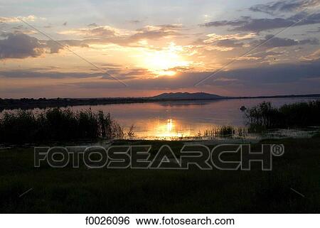 Stock Photograph - Romania, Dobruja, near Murighiol, sunset on the Danube Delta. Fotosearch