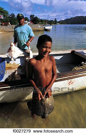 Stock Photo - Seychelles, young boy returning from fishing. Fotosearch