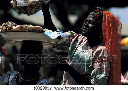 Togo, Tchamba, market, woman choosing a foulard View Large Photo Image Stock Photo - Togo, Tchamba, market, woman choosing a foulard. Fotosearch