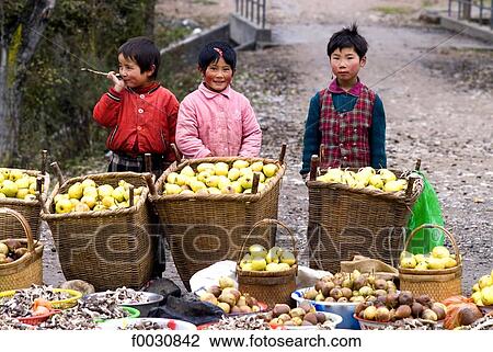 Stock Image - China, Gansu, Hui muslim ethnos children selling apples. Fotosearch