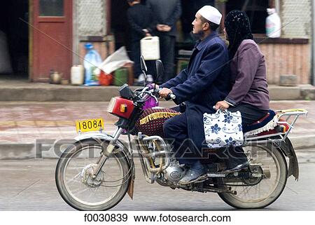 Stock Photo - China, Gansu, Linxia, Hui muslim ethnos couple biking. Fotosearch