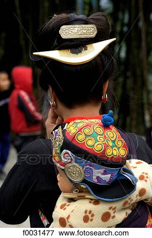 China, Guizhou, Taojiang village, Miao woman carrying her child on her back View Large Photo Image Stock Photo - China, Guizhou, Taojiang village, Miao woman carrying her child on her back. Fotosearch