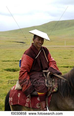Stock Photo - China, Qinghai, near Gonghé, Tibetan monk travelling by horse. Fotosearch