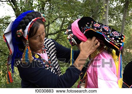 Stock Image - China, Sichuan, near Danba, Tibetan women preparing themselves for village festival. Fotosearch