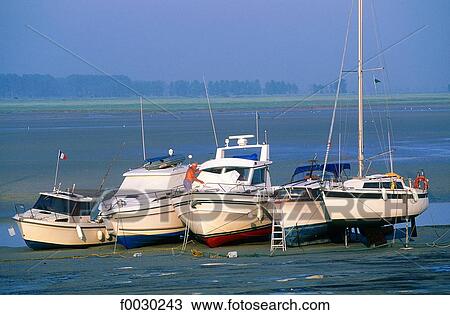 Stock Image - France, Normandy, Mont Saint-Michel, sailing boats ashore at low tide. Fotosearch