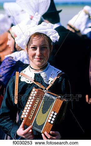 Stock Image - France, Normandy, Mont Saint-Michel, festival, young lady dressed in ancient costume with an accordion. Fotosearch