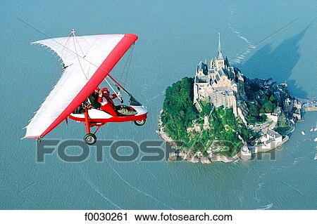 France, Normandy, Mont Saint-Michel, ultralight flying above the mount at high tide, aerial view View Large Photo Image Stock Image - France, Normandy, Mont Saint-Michel, ultralight flying above the mount at high tide, aerial view. Fotosearch
