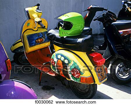 Stock Image - French Polynesia, Society Islands, Bora Bora island, colored scooter and helmet. Fotosearch