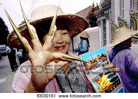 Stock Image - Thailand, Bangkok, by Wat Po temple, woman selling post cards and false nails used for dancing. Fotosearch