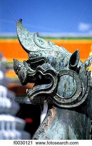 Stock Image - Thailand, Bangkok, Grand Palace and emerald Buddha temple "Wat Phra Keo", head of a bronze dragon. Fotosearch