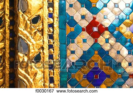 Stock Photo - Thailand, Bangkok, Grand Palace and emerald Buddha temple "Wat Phra Keo", close-up on a carved frieze with colored glass. Fotosearch