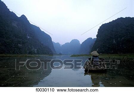 Vietnam, Hoa Lu bay, woman on a small boat View Large Photo Image Stock Image - Vietnam, Hoa Lu bay, woman on a small boat. Fotosearch