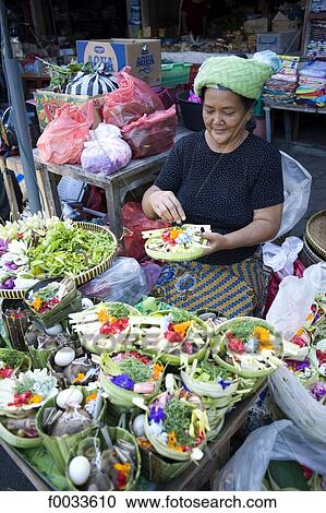 Stock Image - Indonesia, Bali, Gianyar, woman preparing offerings for a ceremony. Fotosearch