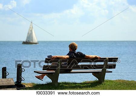 Stock Image - The Netherlands, North Holland, Marken, man on a bench. Fotosearch