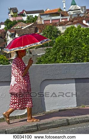 Stock Image - Indonesia, Java, Yogyakarta, old woman with an umbrella. Fotosearch