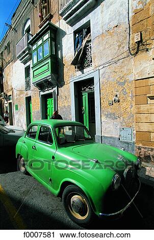 Stock Image - Malta, Mdina, stone house and old green car. Fotosearch