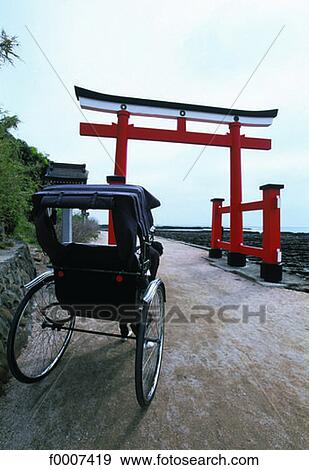 Japan, Miyazaki, rickshaw in front of "torii" temple View Large Photo Image Stock Photo - Japan, Miyazaki, rickshaw in front of "torii" temple. Fotosearch