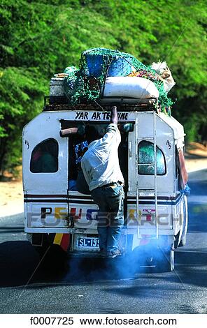 Senegal, Saint-Louis, man holding on to truck View Large Photo Image Stock Photography - Senegal, Saint-Louis, man holding on to truck. Fotosearch