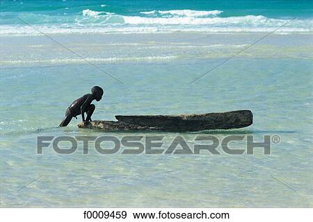 Senegal, Cayar, young boy and pirogue View Large Photo Image Stock Photo - Senegal, Cayar, young boy and pirogue. Fotosearch