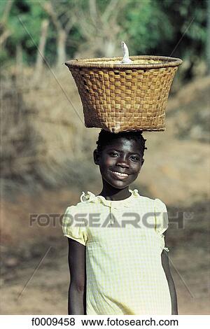 Stock Photo - Senegal, Young girl carrying a basket. Fotosearch