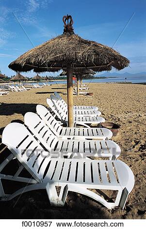 Stock Photo - Nusa Dua beach, empty deck chairs. Fotosearch