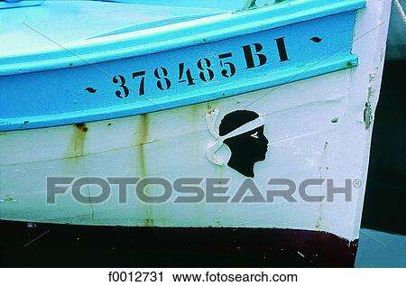 Stock Image - Corsica, Bastia, Maure head (Corsican symbol) on a fishing boat. Fotosearch