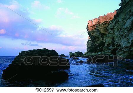 Stock Photo - Corsica, Bonifacio, view on the cliffs and overhanging Citadel at sunrise. Fotosearch