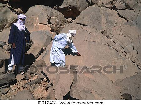 Algeria, Hoggar, Tuareg showing prehistoric paintings View Large Photo Image Stock Image - Algeria, Hoggar, Tuareg showing prehistoric paintings. Fotosearch