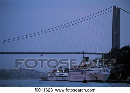 Stock Image - Turkey, Istanbul, Bridge on the Bosphorus and yachts at dusk. Fotosearch