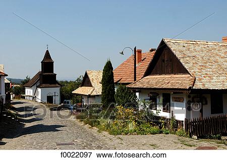 Stock Photo - Hungary, Hollokö, traditional church and houses. Fotosearch