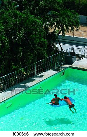Stock Image - Florida, Miami Beach, couple in swimming pool. Fotosearch