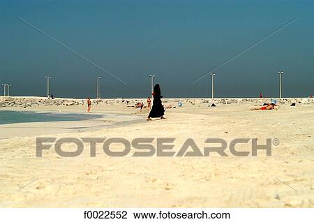 Stock Image - United Arab Emirates, Dubai, beach, veiled woman. Fotosearch