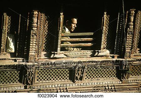 Nepal, Kathmandu, Durbar Square, man looking out of a sculpted window View Large Photo Image Picture - Nepal, Kathmandu, Durbar Square, man looking out of a sculpted window. Fotosearch