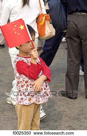 Stock Image - China, Beijing, Tiananmen Square, during the National Day, young girl with a chinese flag. Fotosearch