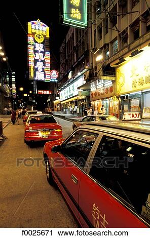 Stock Image - China, Hong Kong, Central District, cabs by night. Fotosearch