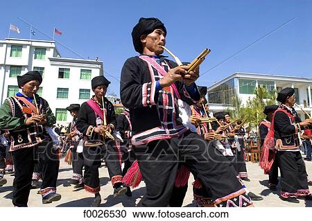 Stock Image - China, Yunnan, Lancang, Lahu men playing the traditional flute. Fotosearch
