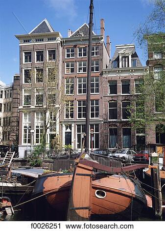Stock Image - The Netherlands, North Holland, Amsterdam, old sailing boats on canal. Fotosearch