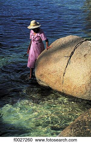 Stock Image - Seychelles, Praslin, woman and rock. Fotosearch