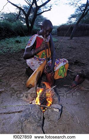 Stock Photo - Kenya, Il Ngwesi, Maasai woman cooking. Fotosearch