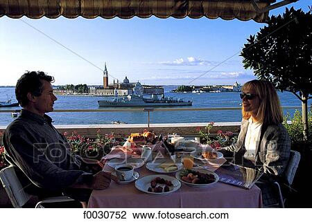 Stock Image - Italie, Venise, petit déjeuner en couple et basilique San Giorgio Maggiore en arrière-plan. Fotosearch