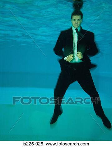 Stock Photography - A man in a suit under the water. Fotosearch