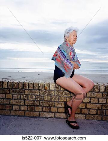 A mature woman sitting by the sea View Large Photo Image Stock Photo - A mature woman sitting by the sea. Fotosearch
