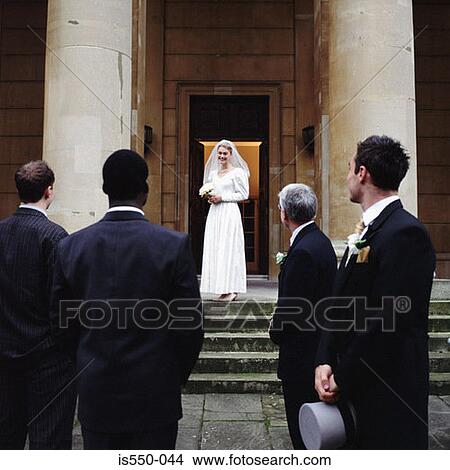 Picture - Groom, friends and family look at the bride. Fotosearch