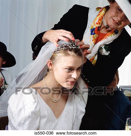 Stock Photograph - Mother helps bride with veil. Fotosearch