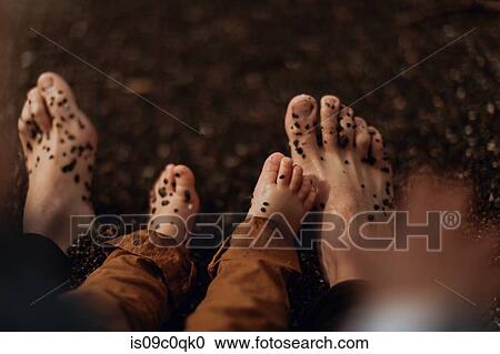 Adult and toddler's feet playing with pebbles on beach View Large Photo Image Stock Image - Adult and toddler's feet playing with pebbles on beach. Fotosearch