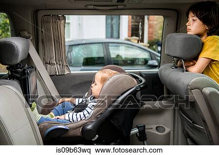 Stock Photography - Baby and big brother watching movie in car. Fotosearch