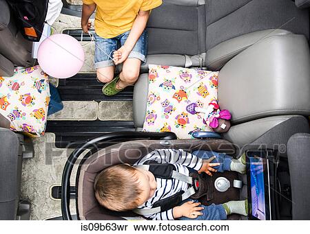 Baby and big brother watching movie in car View Large Photo Image Stock Photography - Baby and big brother watching movie in car. Fotosearch