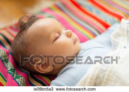 Baby boy asleep on colourful textile View Large Photo Image Stock Image - Baby boy asleep on colourful textile. Fotosearch