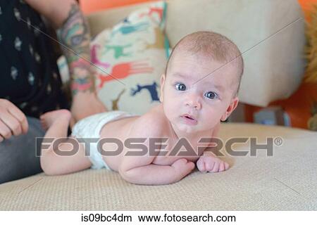 Picture - Baby boy lying on bed. Fotosearch